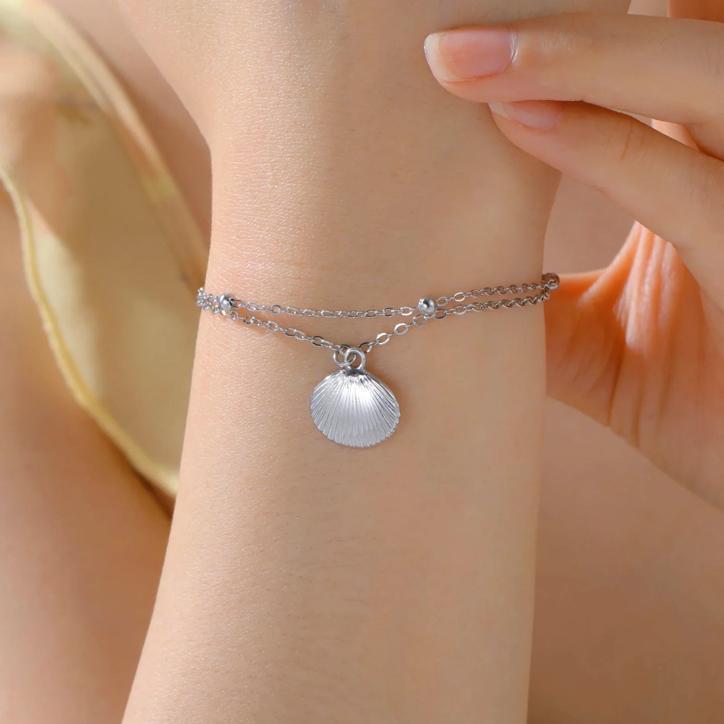 Elegant women's bracelet made of stainless steel with shell pendant in color