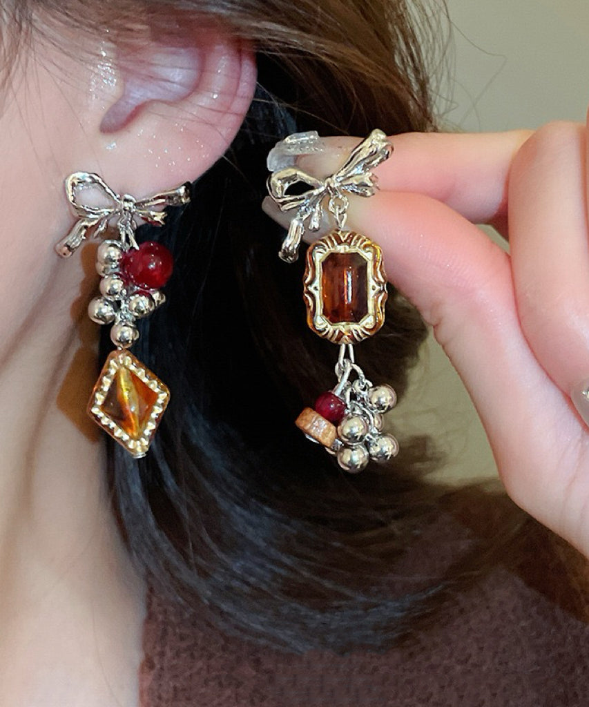 Boucles d'oreilles pendantes vintage asymétriques en alliage acrylique avec nœud ambré et pompon - TrendAura